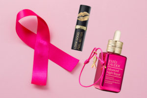 A pink ribbon on a pastel pink background. Breast cancer concept