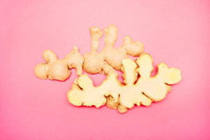 High angle view of a halved ginger root on pink background