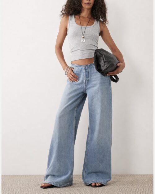 Model mit grauem Tanktop und heller Wide-Leg-Jeans mit besonderem Bund